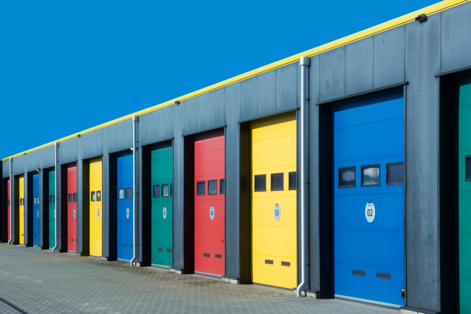 Illustrative stock photograph of a row of individual industrial units with at-grade garage doors
